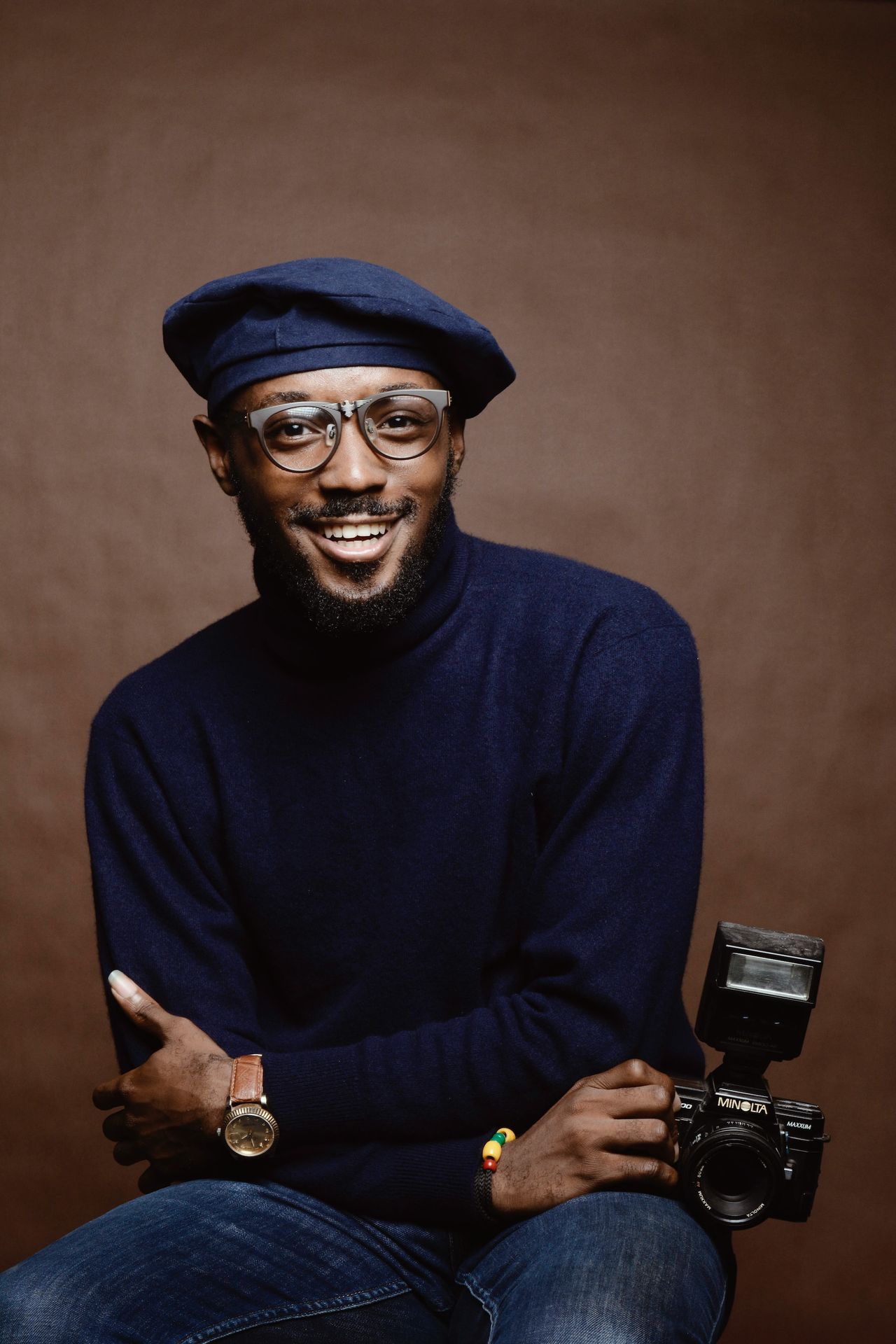 smiling man wearing black turtleneck shirt holding camrea